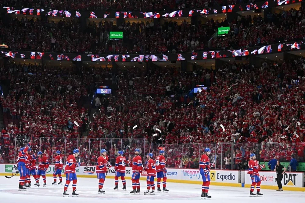 Players hold sticks high to acknowledge the Bell Centre crowd.